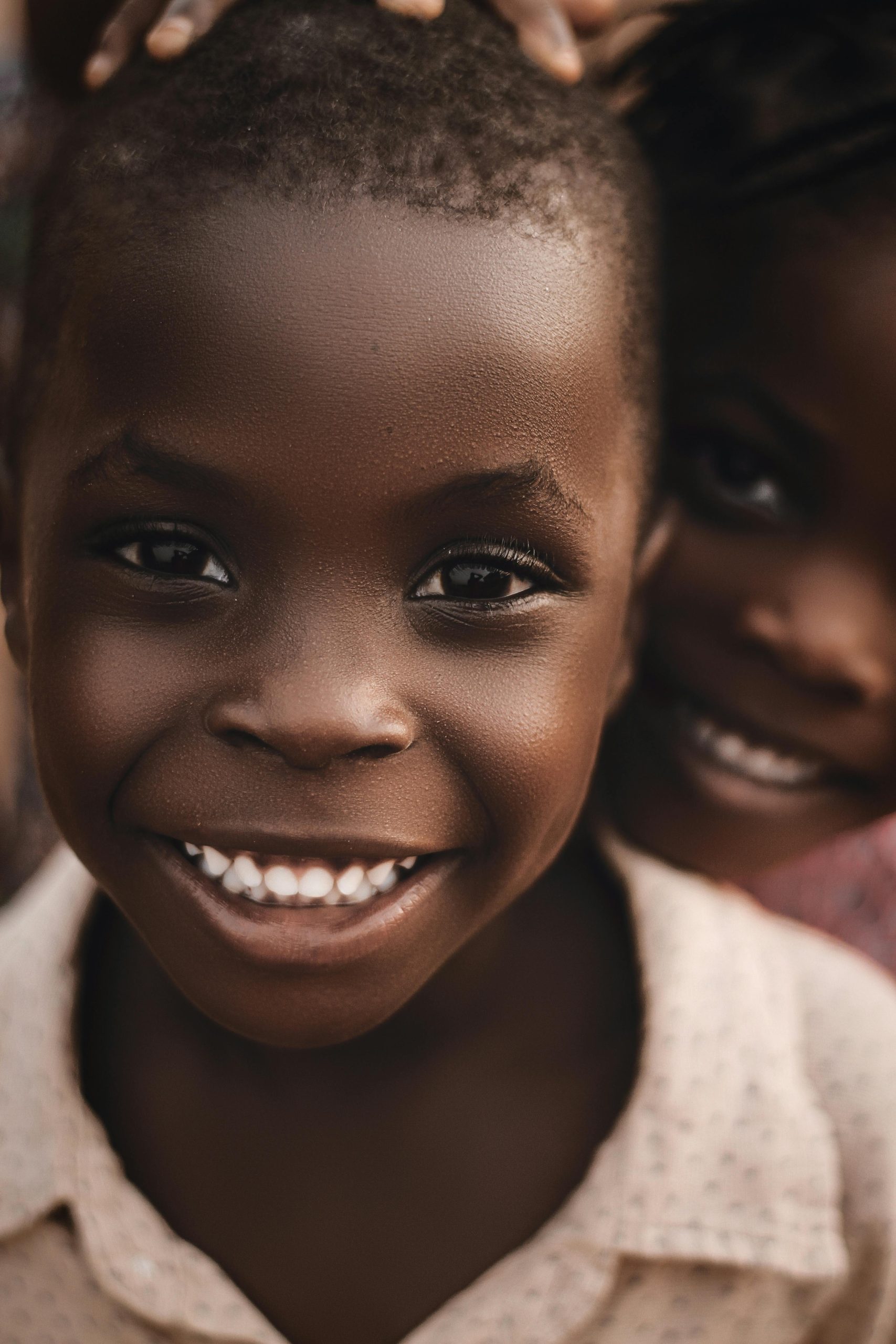 Close-up of smiling African children outdoors in Nigeria, capturing joy and innocence.